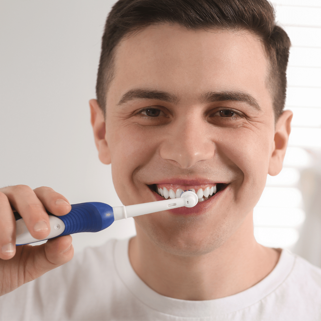 Man brushing teeth with an electric toothbrush